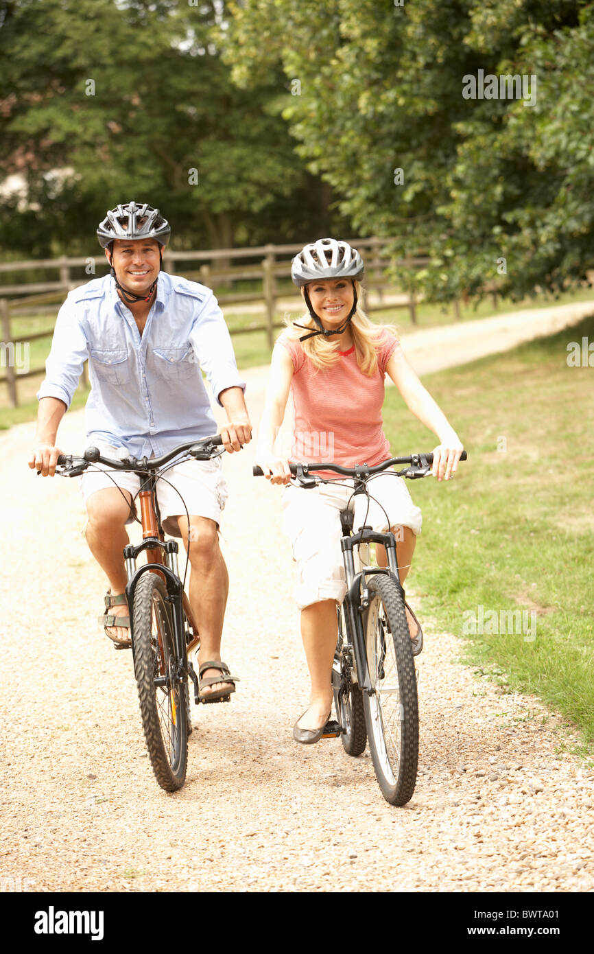 Giovane Escursioni in bicicletta nelle campagne di indossare i caschi di sicurezza Foto Stock