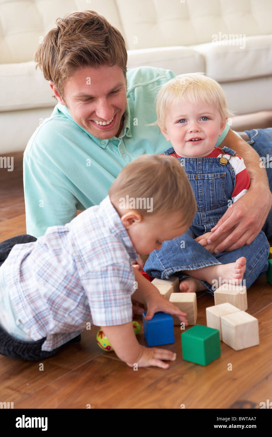 Padre e figli giocare con i blocchi colorati a casa Foto Stock