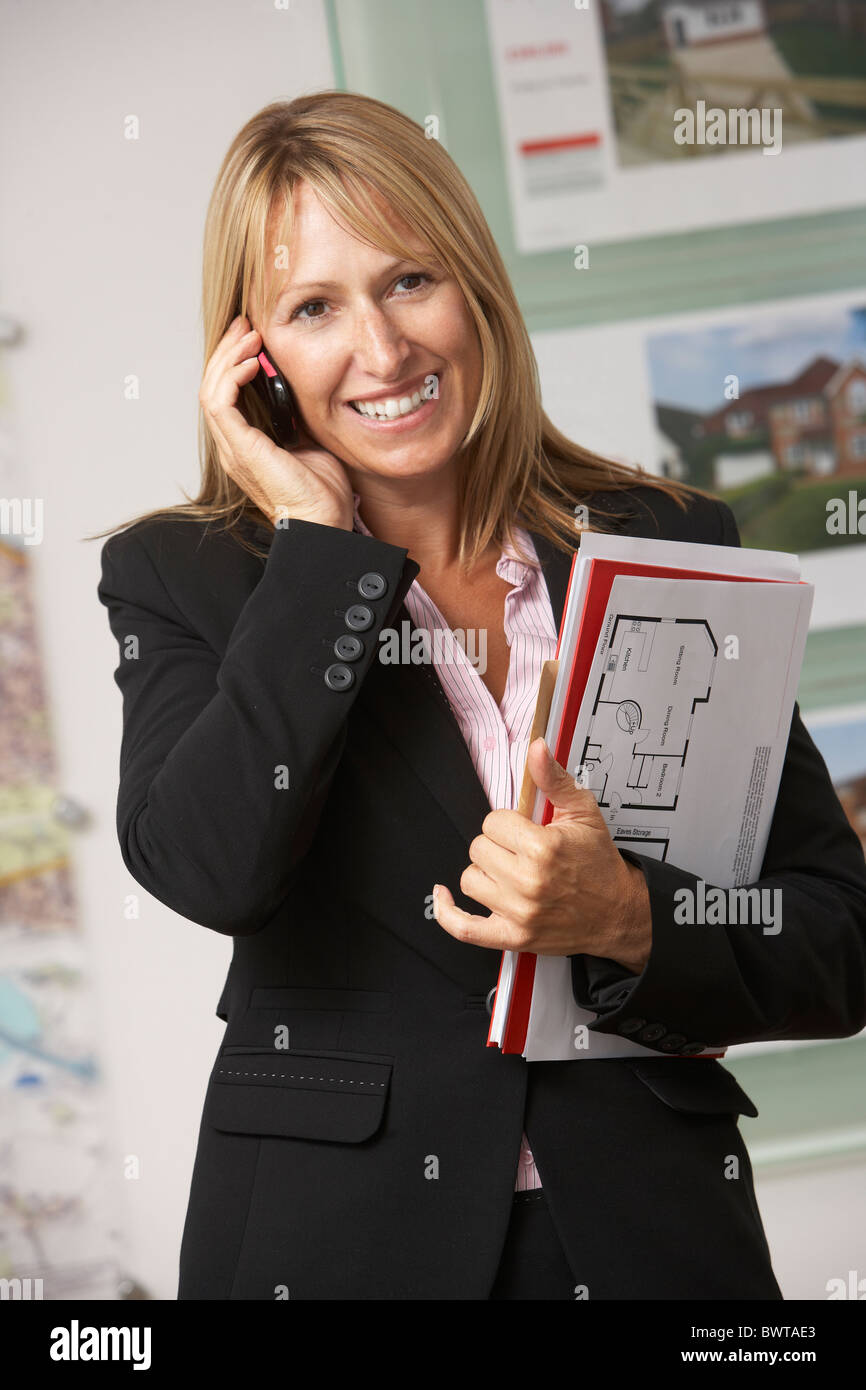 Ritratto di donna Agente Immobiliare in Office sul telefono Foto Stock
