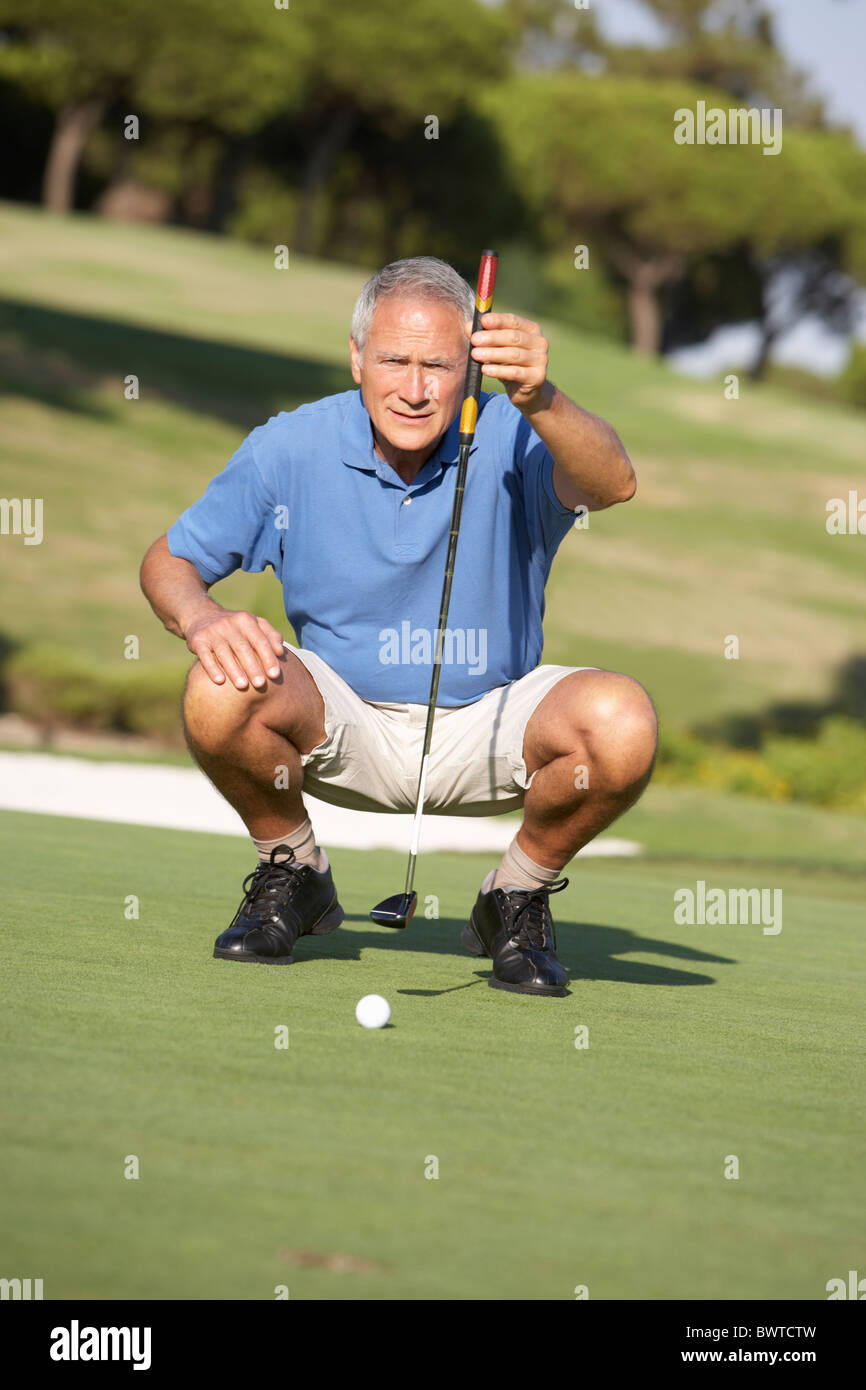 Senior Golfer maschio Campo da Golf Putt Green Foto Stock