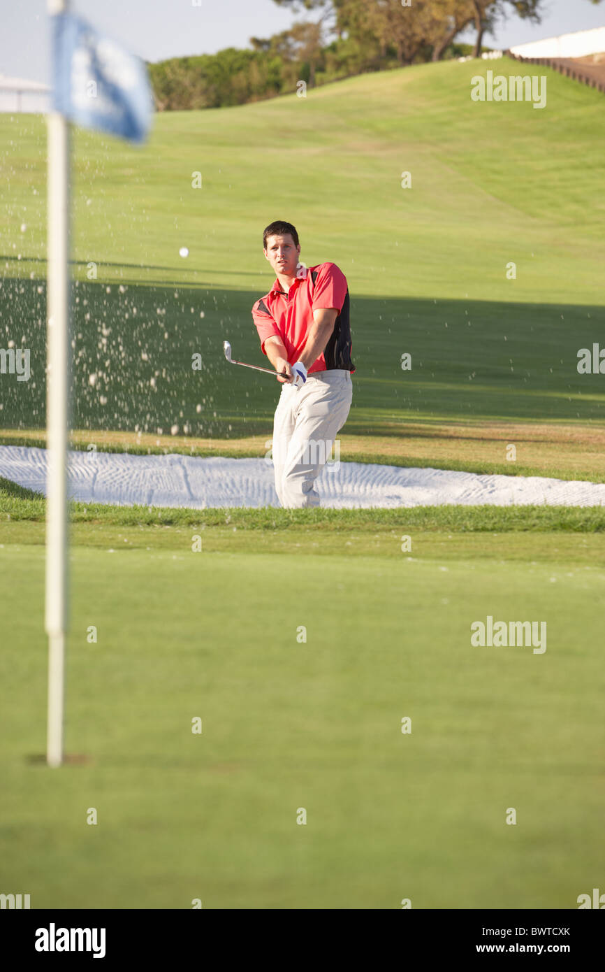 Golfista maschio giocando Bunker Shot sul campo da Golf Foto Stock
