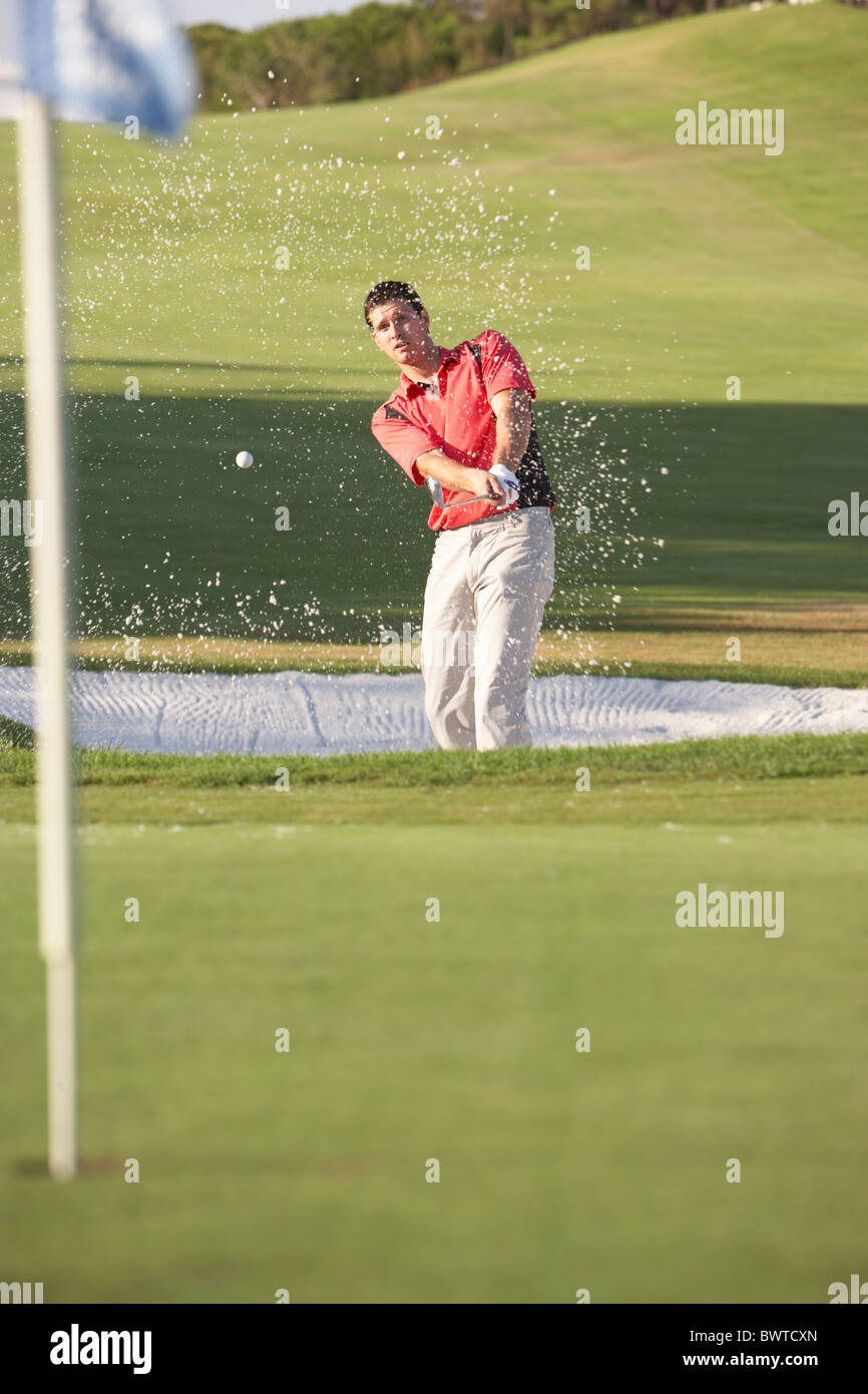 Golfista maschio giocando Bunker Shot sul campo da Golf Foto Stock