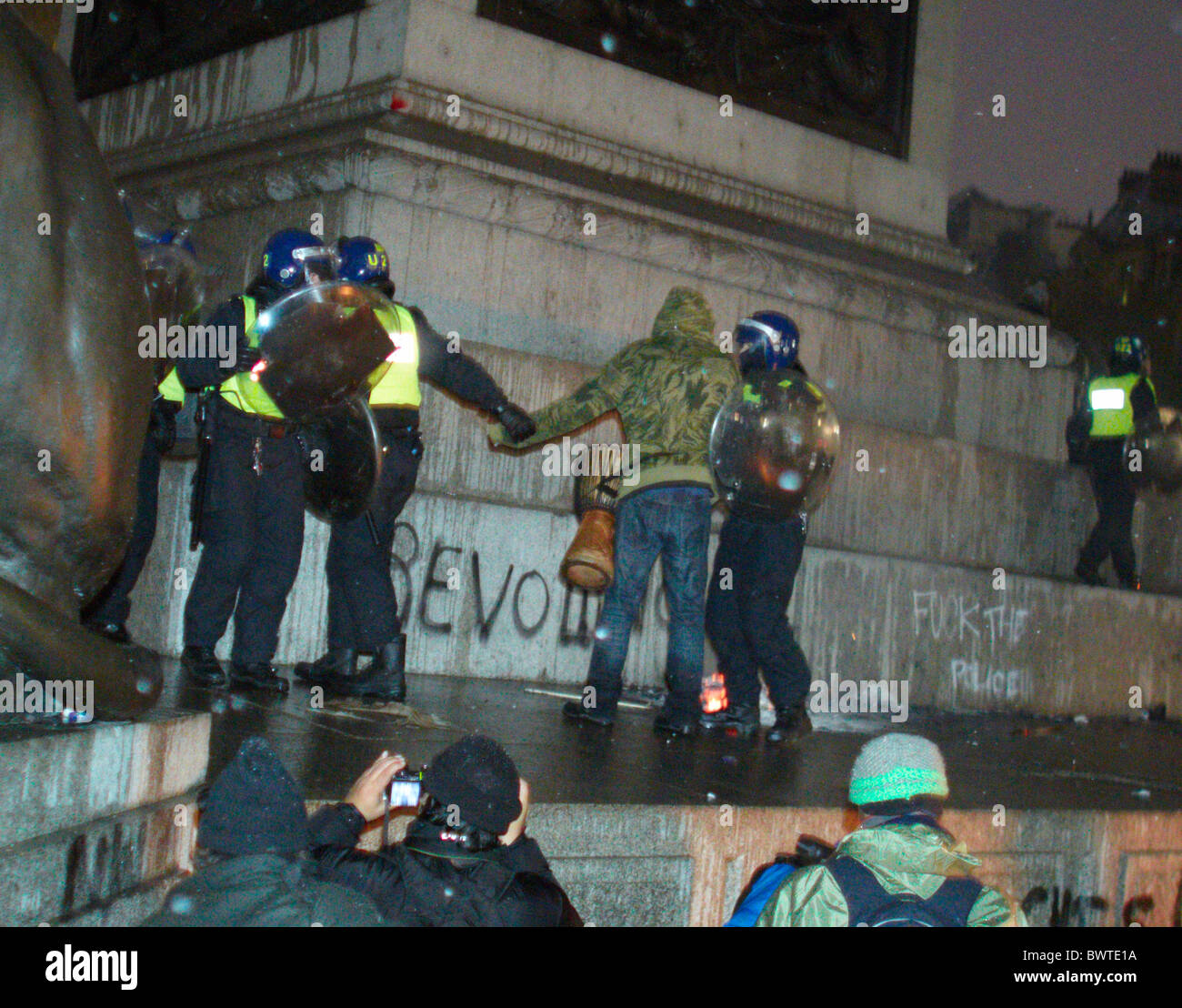 Polizia arrestare un dimostratore su Nelson's colonna durante la protesta studentesca contro le tasse di iscrizione Foto Stock