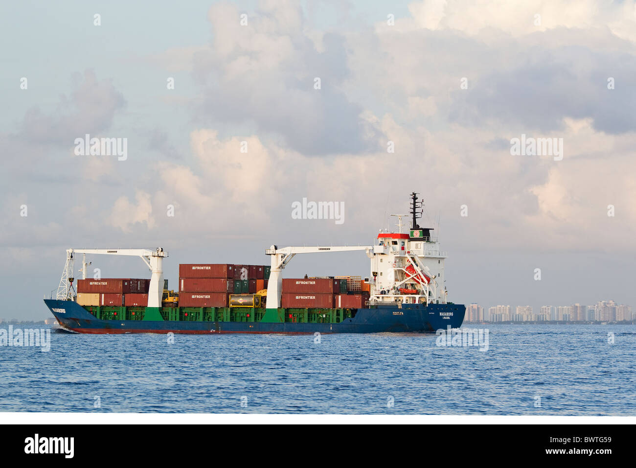 Nave da carico in mare nei pressi di città, Daytona, Florida, con i contenitori di spedizione Foto Stock