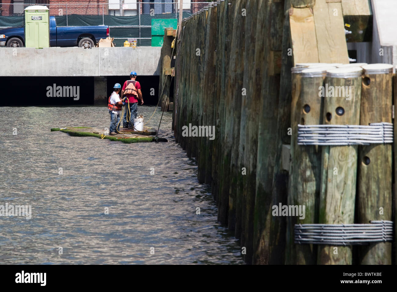 Due lavoratori portuali su zattera accanto al dock in New York City, Stati Uniti d'America Foto Stock