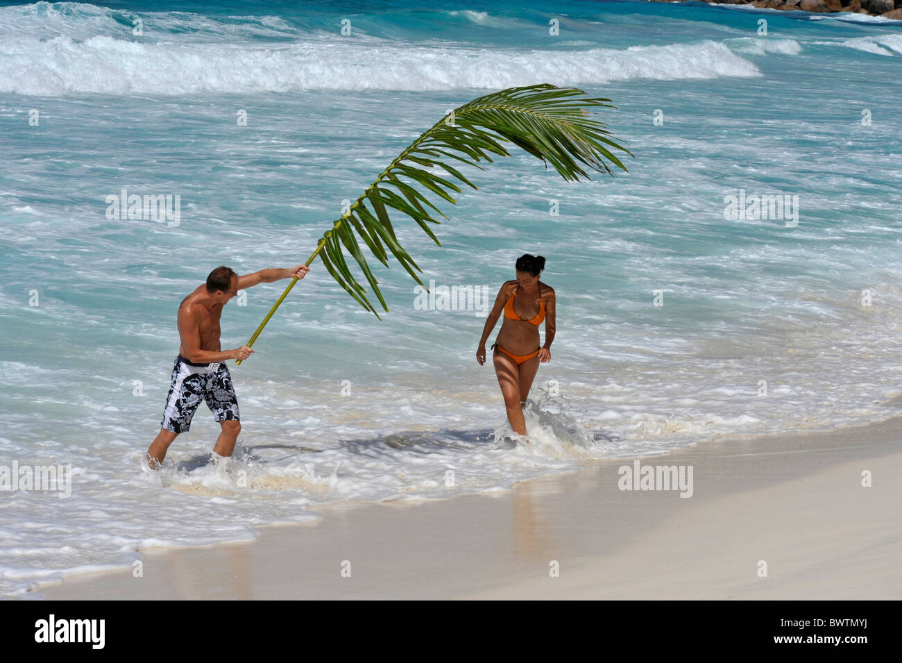 L uomo e la donna sulla spiaggia di Grand Anse, La Digue, Seicelle Foto Stock