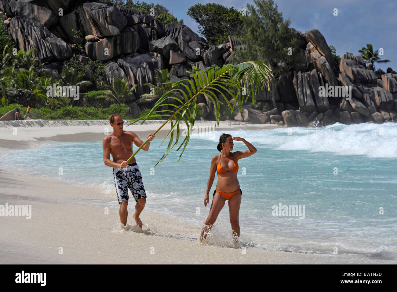L uomo e la donna sulla spiaggia di Grand Anse, La Digue, Seicelle Foto Stock