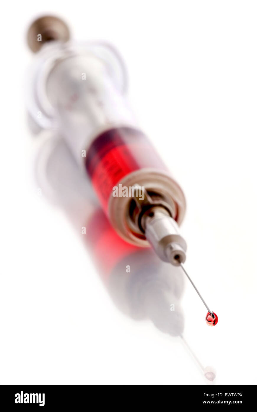 Iniezione di colore rosso con drop come closeup su sfondo bianco Foto Stock