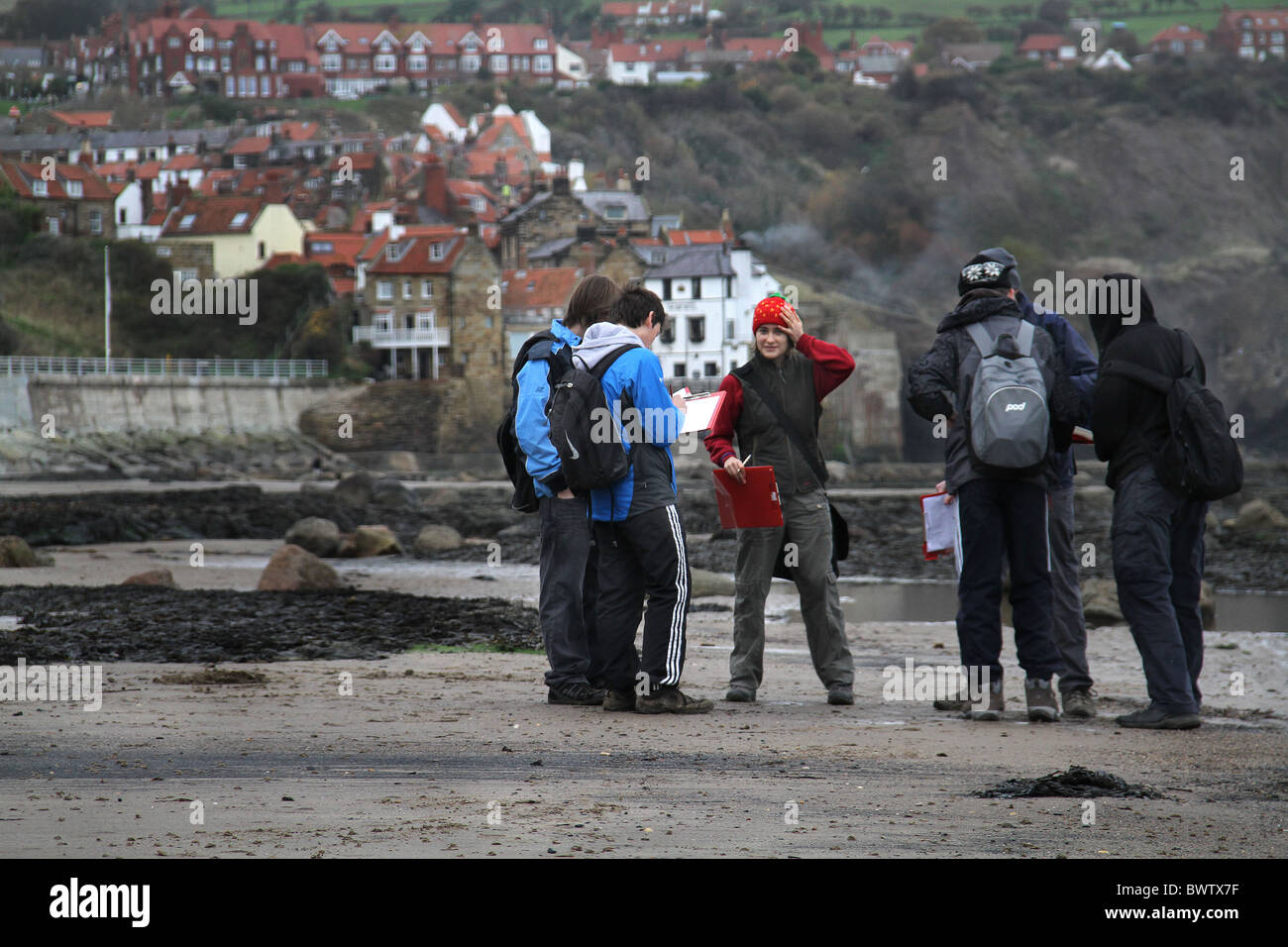 Studenti in gita sulla spiaggia di Robin Hood's Bay nel North Yorkshire con la bassa marea. Foto Stock Studenti in gita sulla spiaggia di Robin Hood's Bay nel North Yorkshire con la bassa marea. Foto Stock