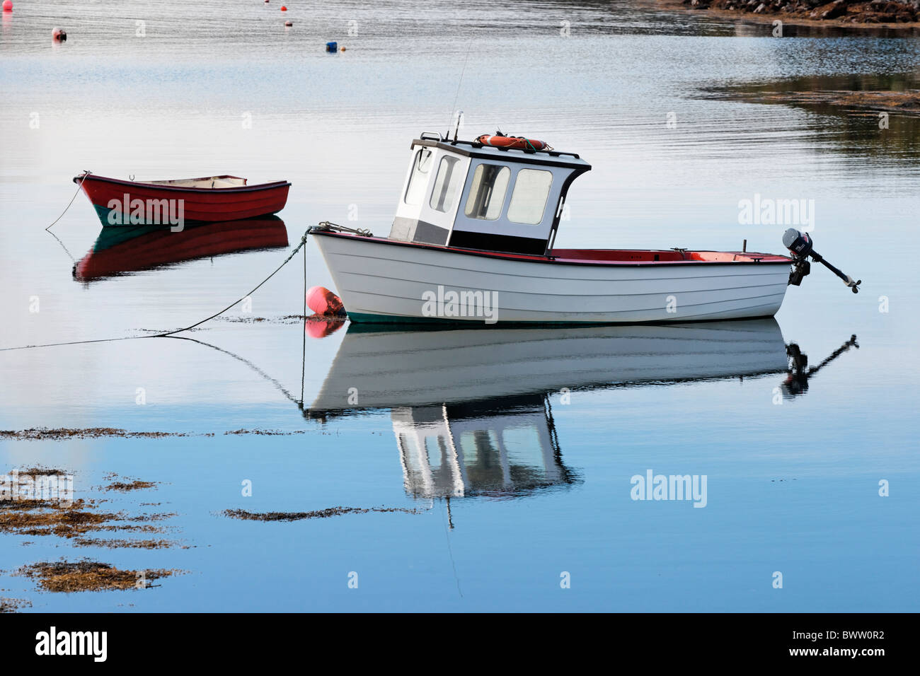 Bianco con una barca a motore ormeggiata in Cove Harbour, il Castello di Baia, County Kerry, munster, irlanda. Foto Stock