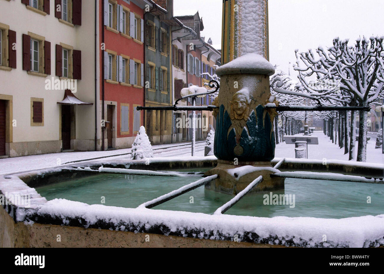 Svizzera Europa Canton Neuchatel Le Landeron Città Vecchia case case alberi fontana neve medievale di inverno Foto Stock