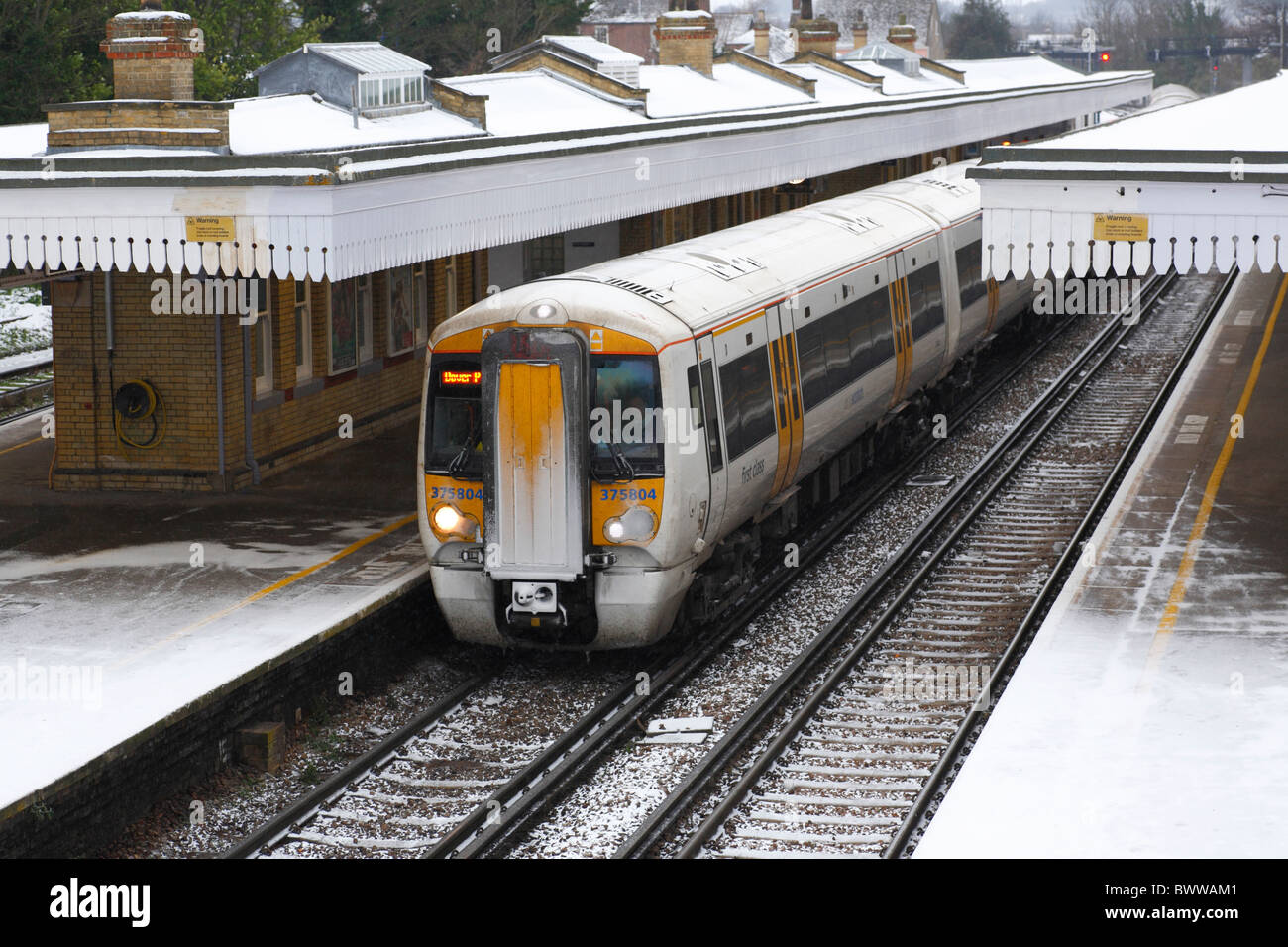 Un treno passeggeri in una stazione in condizioni invernali. Foto Stock