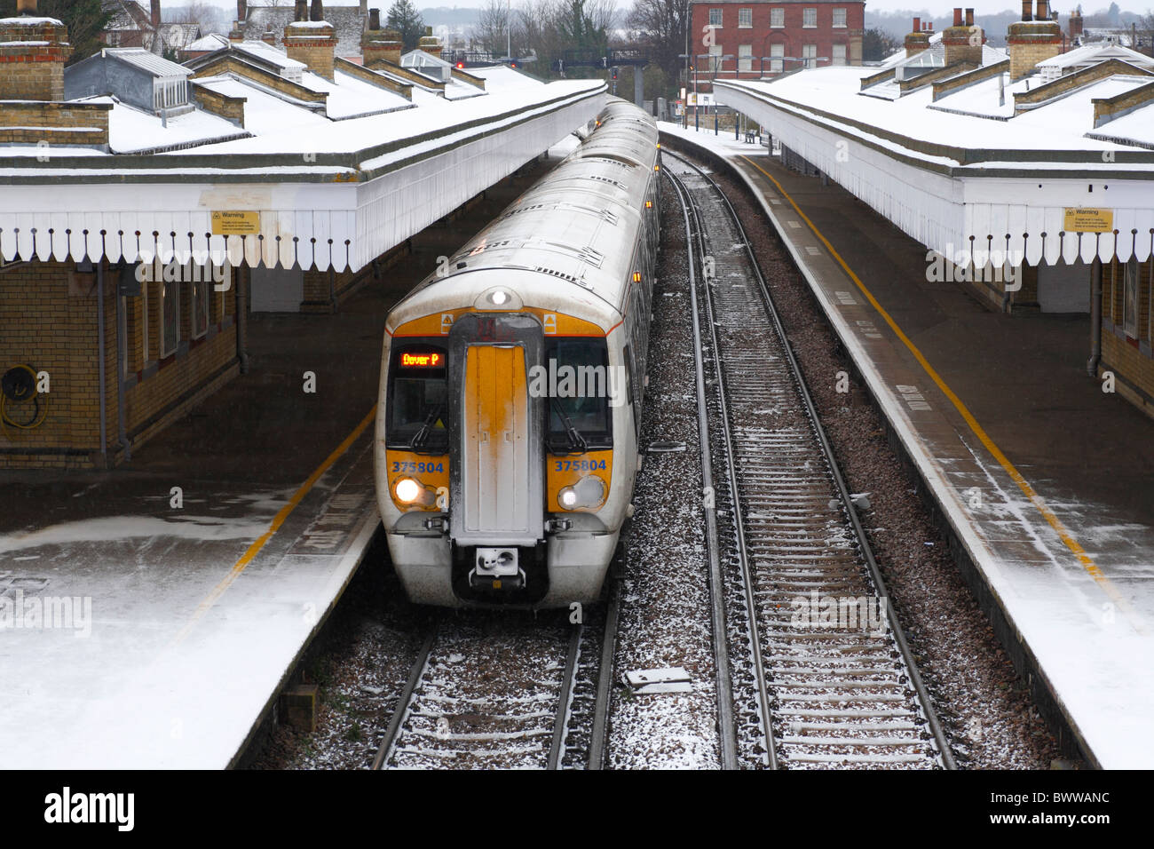 Un treno passeggeri in una stazione in condizioni invernali. Foto Stock
