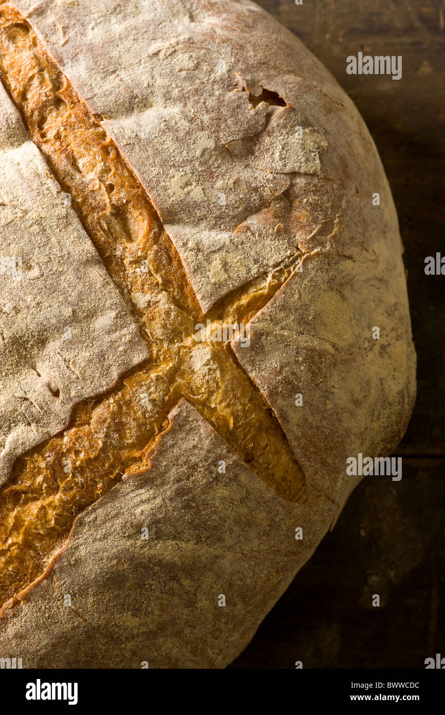 Una pagnotta di pane artigianale su un rustico di superficie di legno. Foto Stock