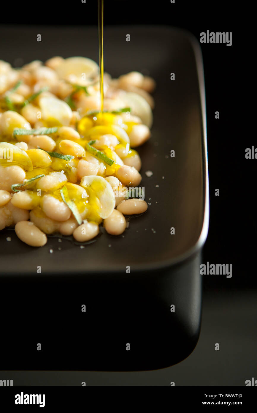 Fagioli bianchi lessati servita con aglio e salvia e olio extra vergine di oliva Foto Stock