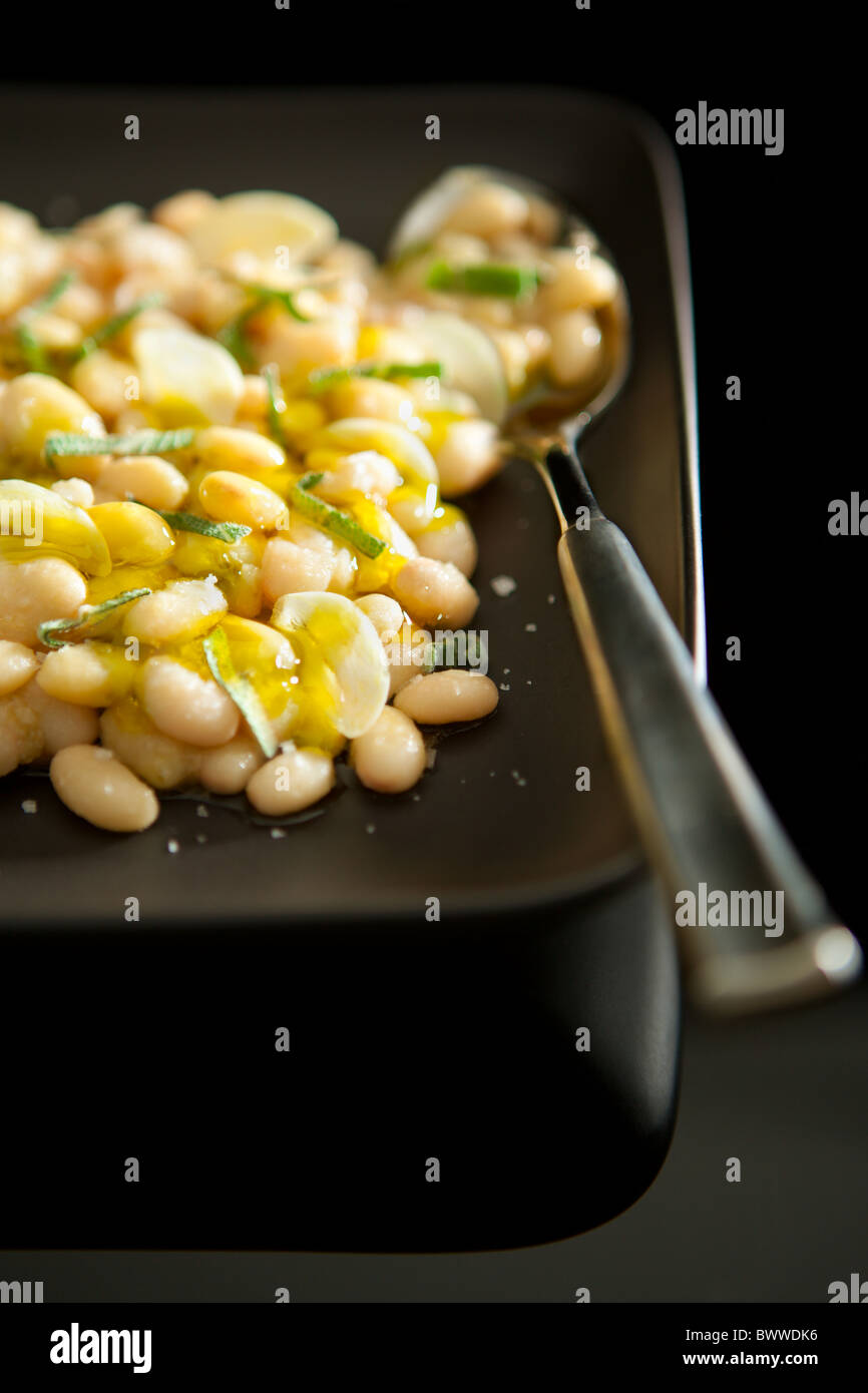 Fagioli bianchi lessati servita con aglio e salvia e olio extra vergine di oliva Foto Stock