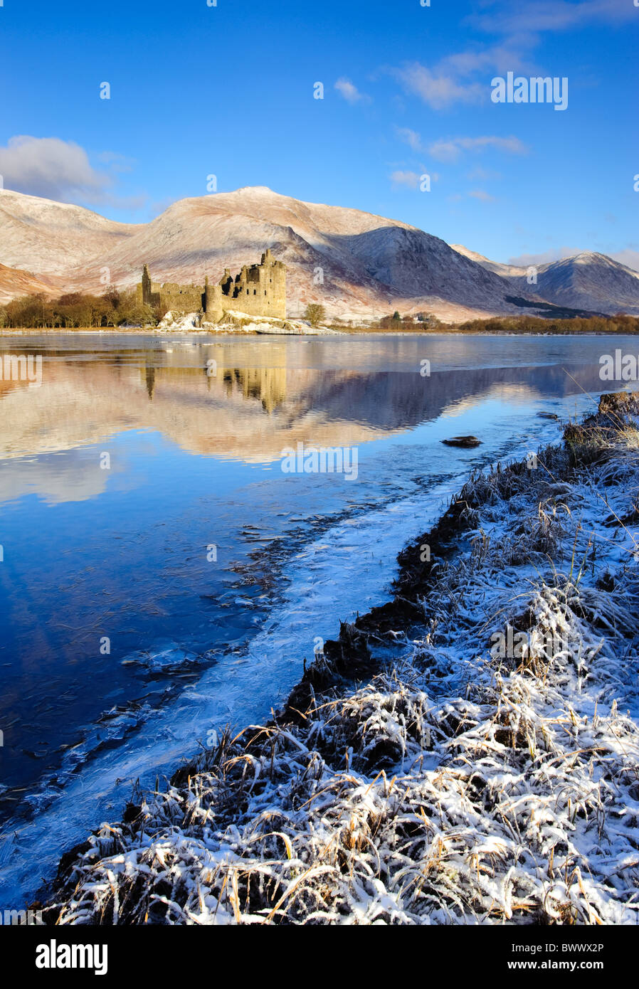 Guardando attraverso un parzialmente congelato Loch Awe e le rovine di Kilchurn Castle in Argyle, Scozia. Foto Stock