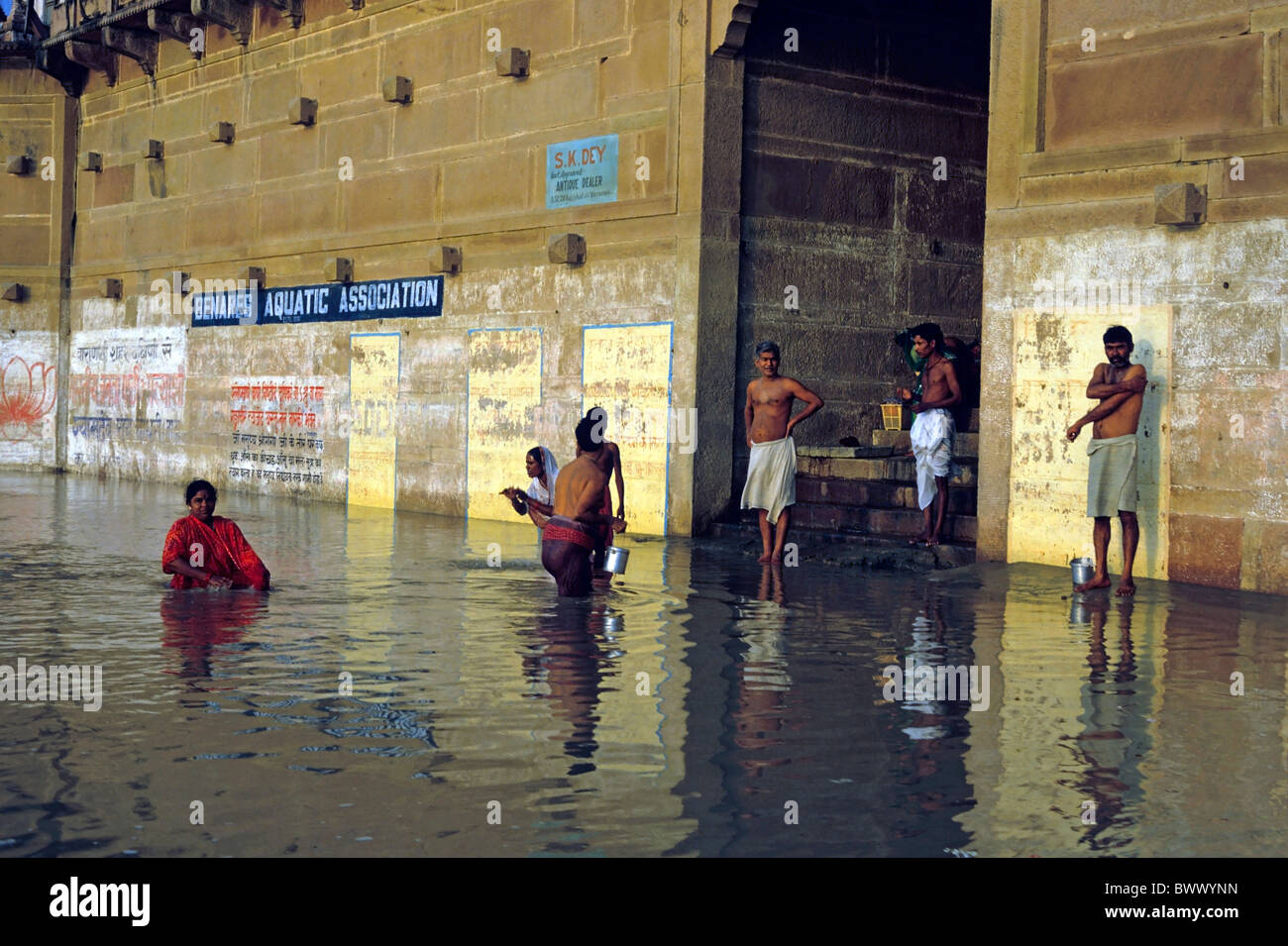 Gli uomini e le donne di eseguire le abluzioni nel fiume Gange, Varanasi (India). Foto Stock