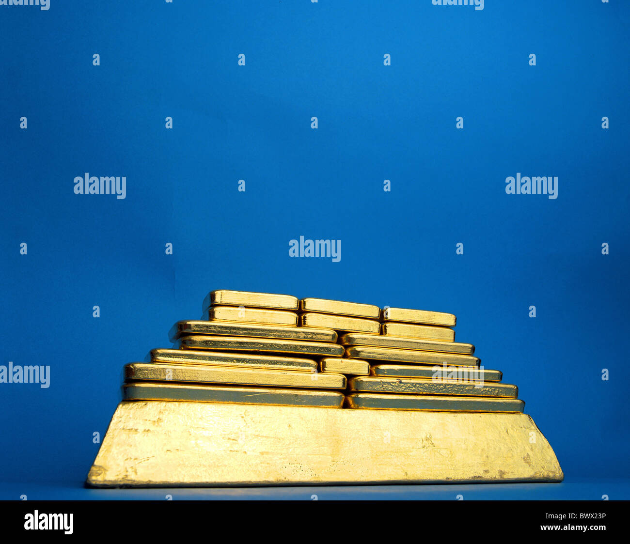 Accatastati in pile accatastate denaro banca oro sfondo blu gold bar piramide Foto Stock