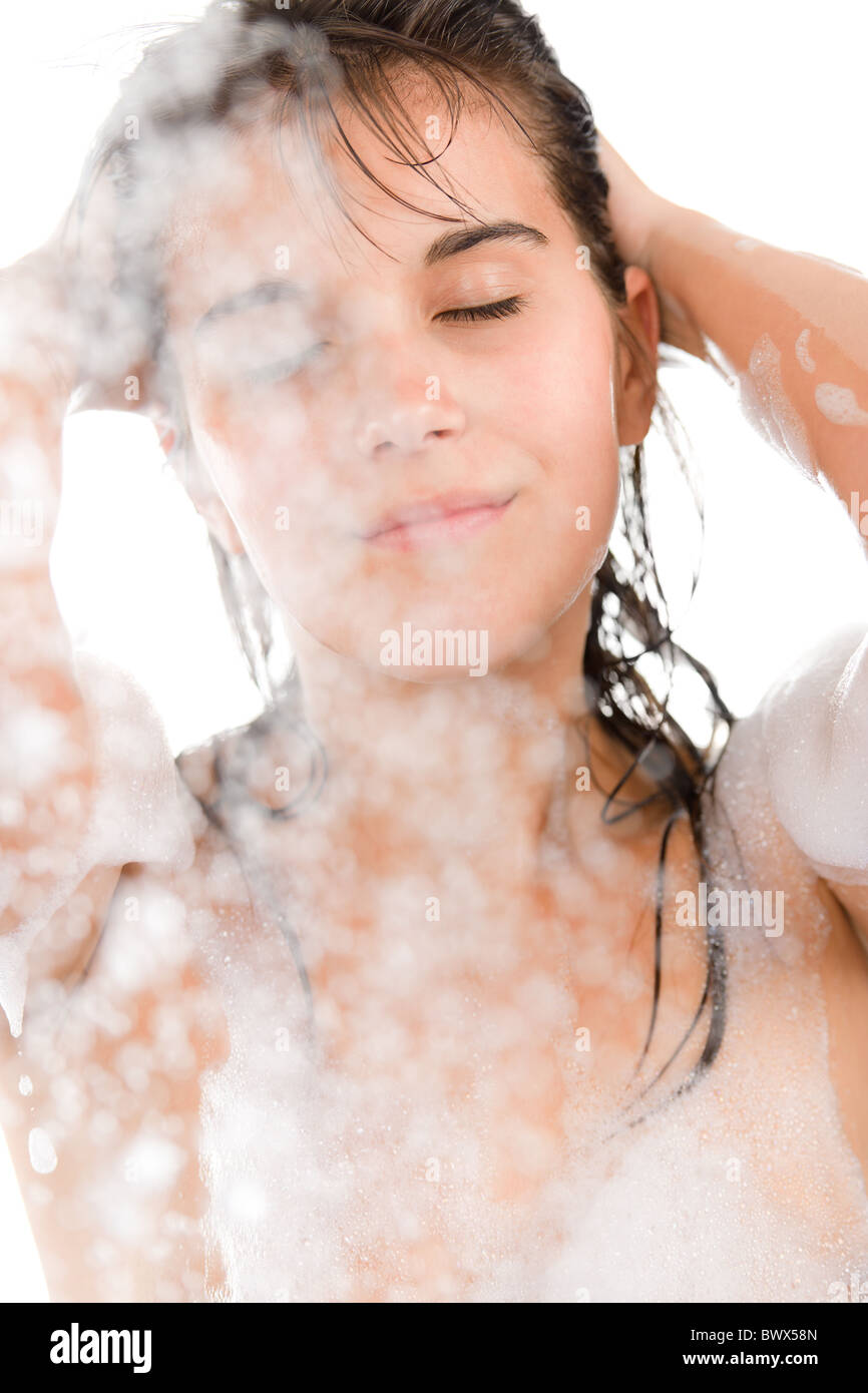 Giovane donna godetevi la doccia su sfondo bianco Foto Stock