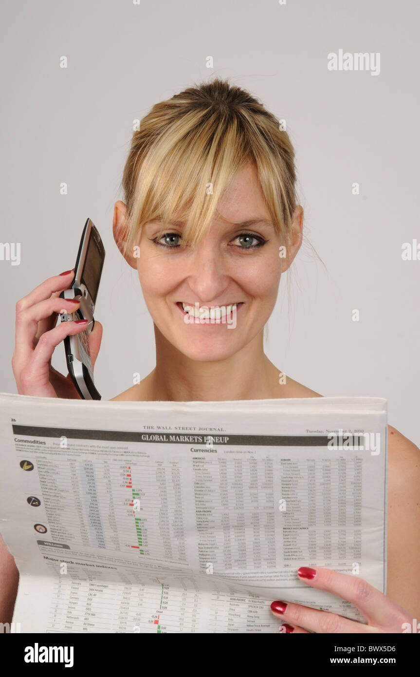 Donna che utilizza un telefono mobile e la lettura del Wall Street Journal Il Giornale le pagine delle finanze Foto Stock