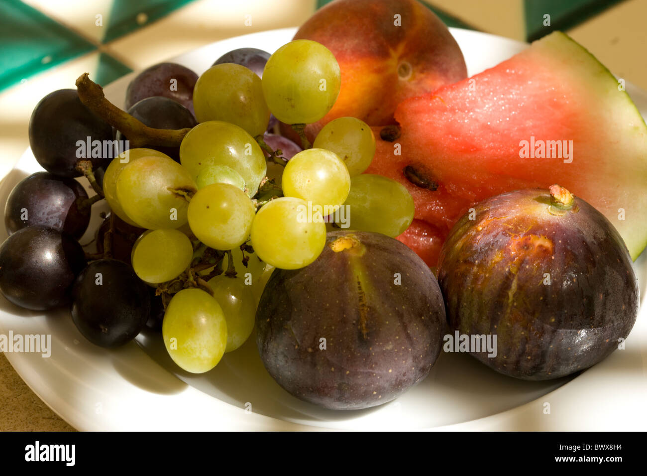 Fichi nero, anguria, uva e una pesca Foto Stock