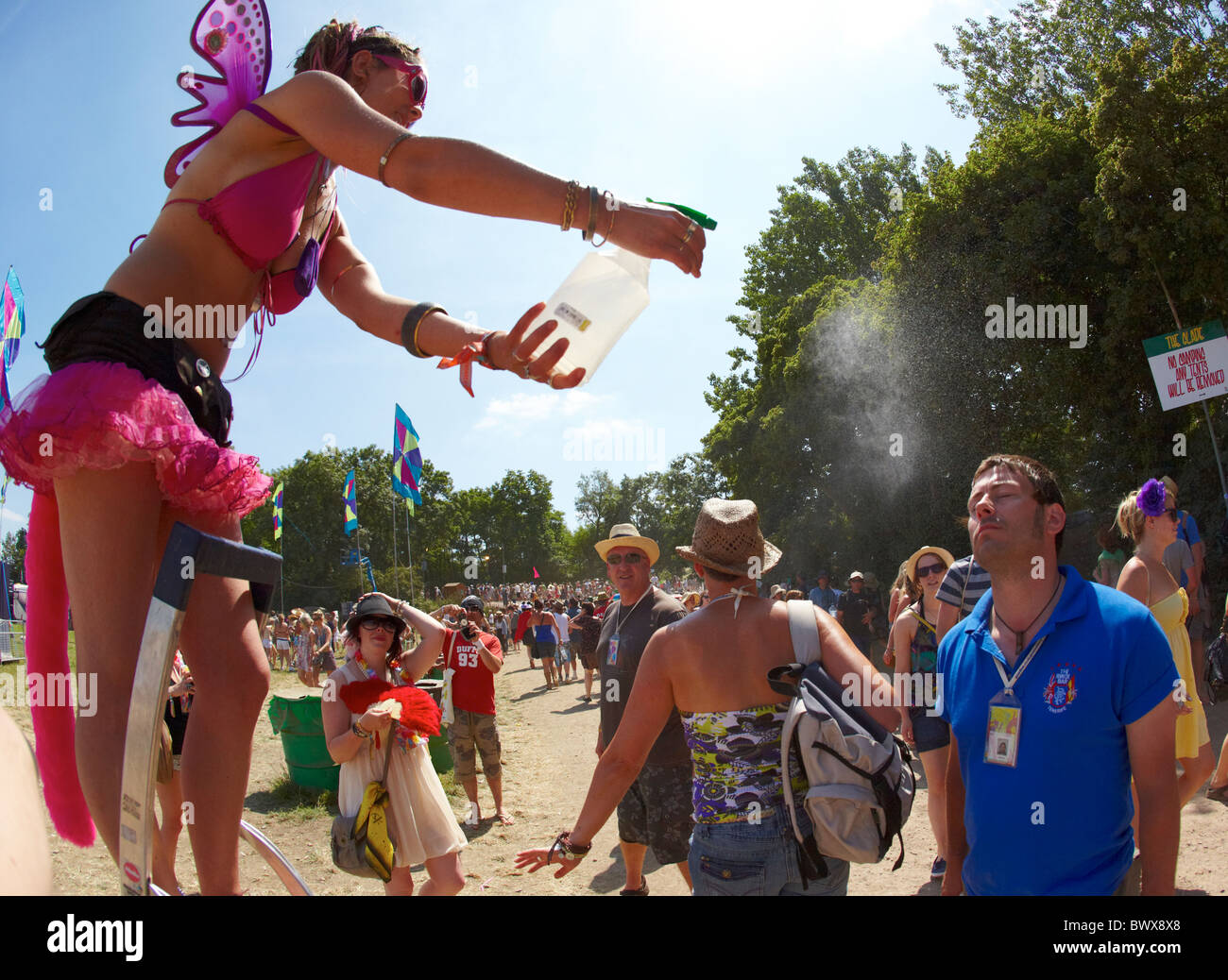 Stiltwalker spruzzare acqua festival di Glastonbury Somerset REGNO UNITO Europa Foto Stock