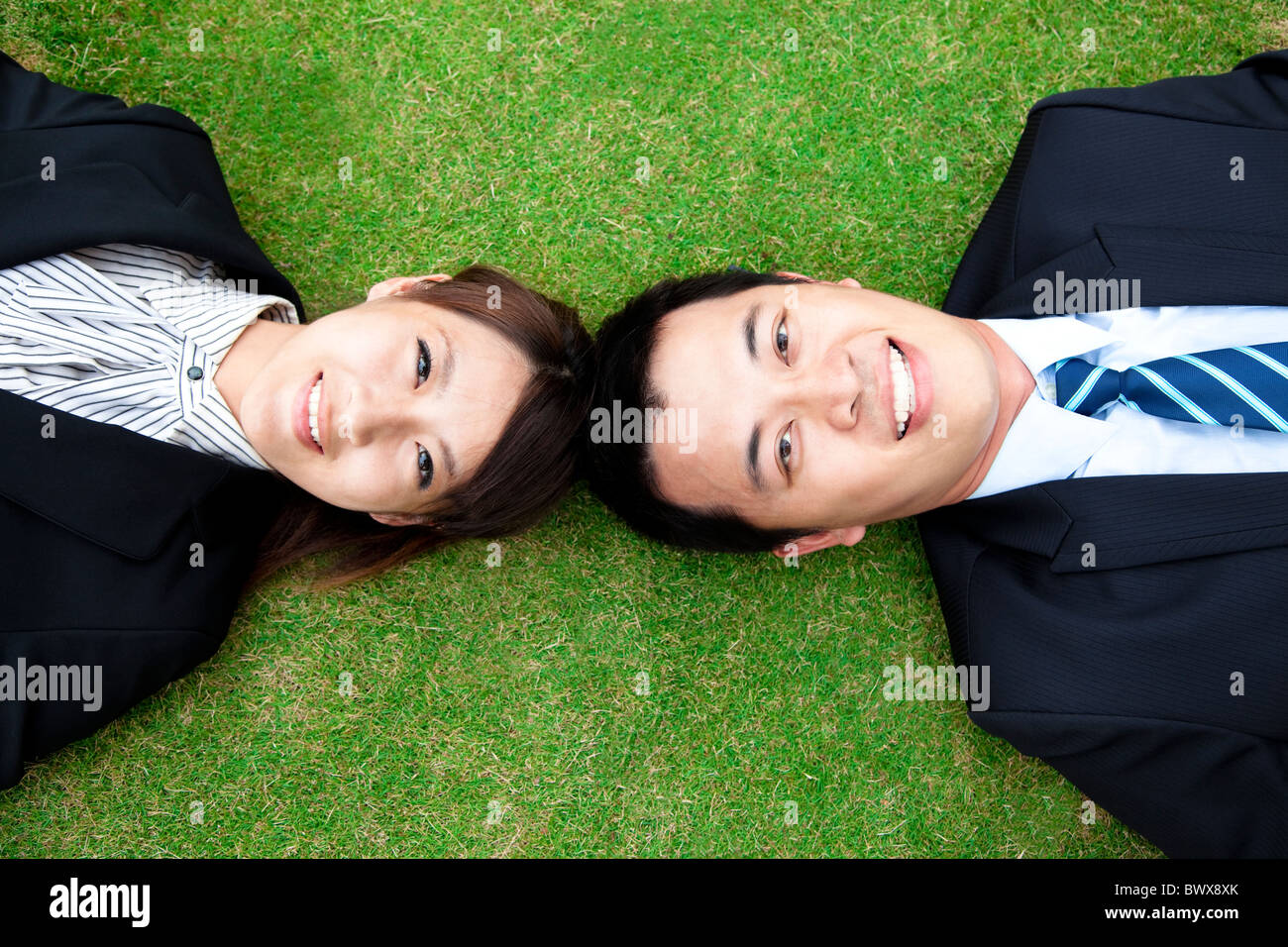 Azienda giovane.happy businessman e donna giaceva sull'erba Foto Stock