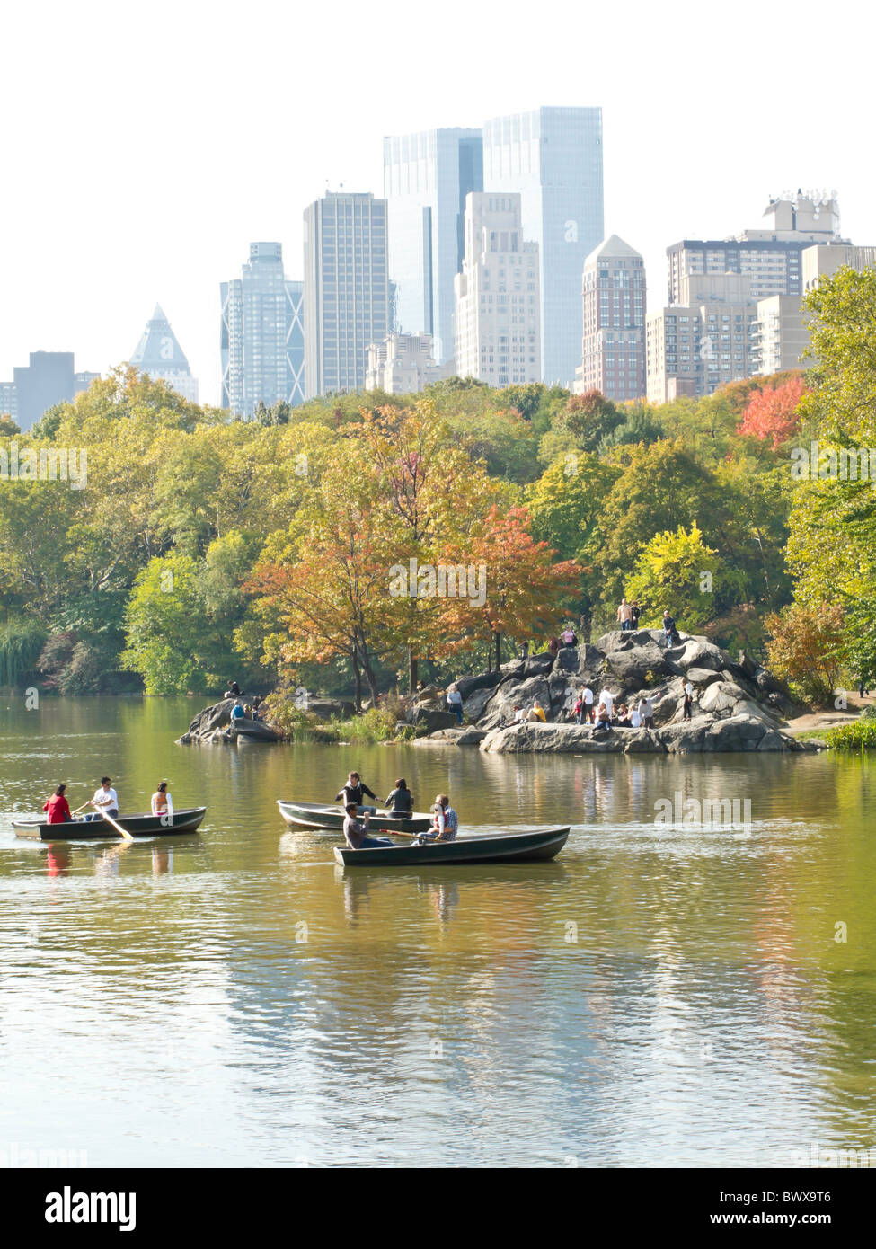 Barche a remi sul lago con il Midtown Skyline di Manhattan, al Central Park di New York Foto Stock