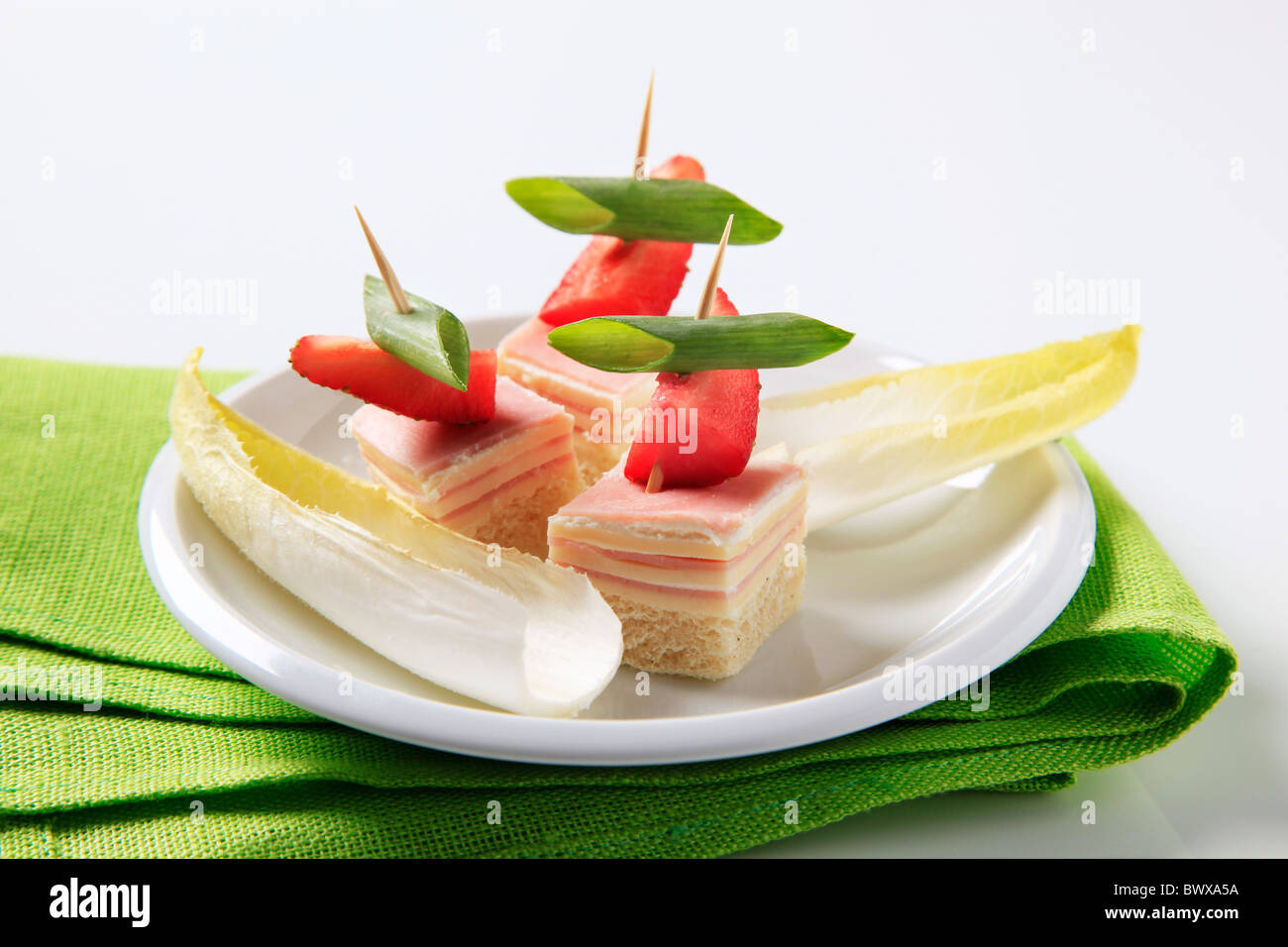 Prosciutto e formaggio tartine e foglie di insalata riccia Foto Stock