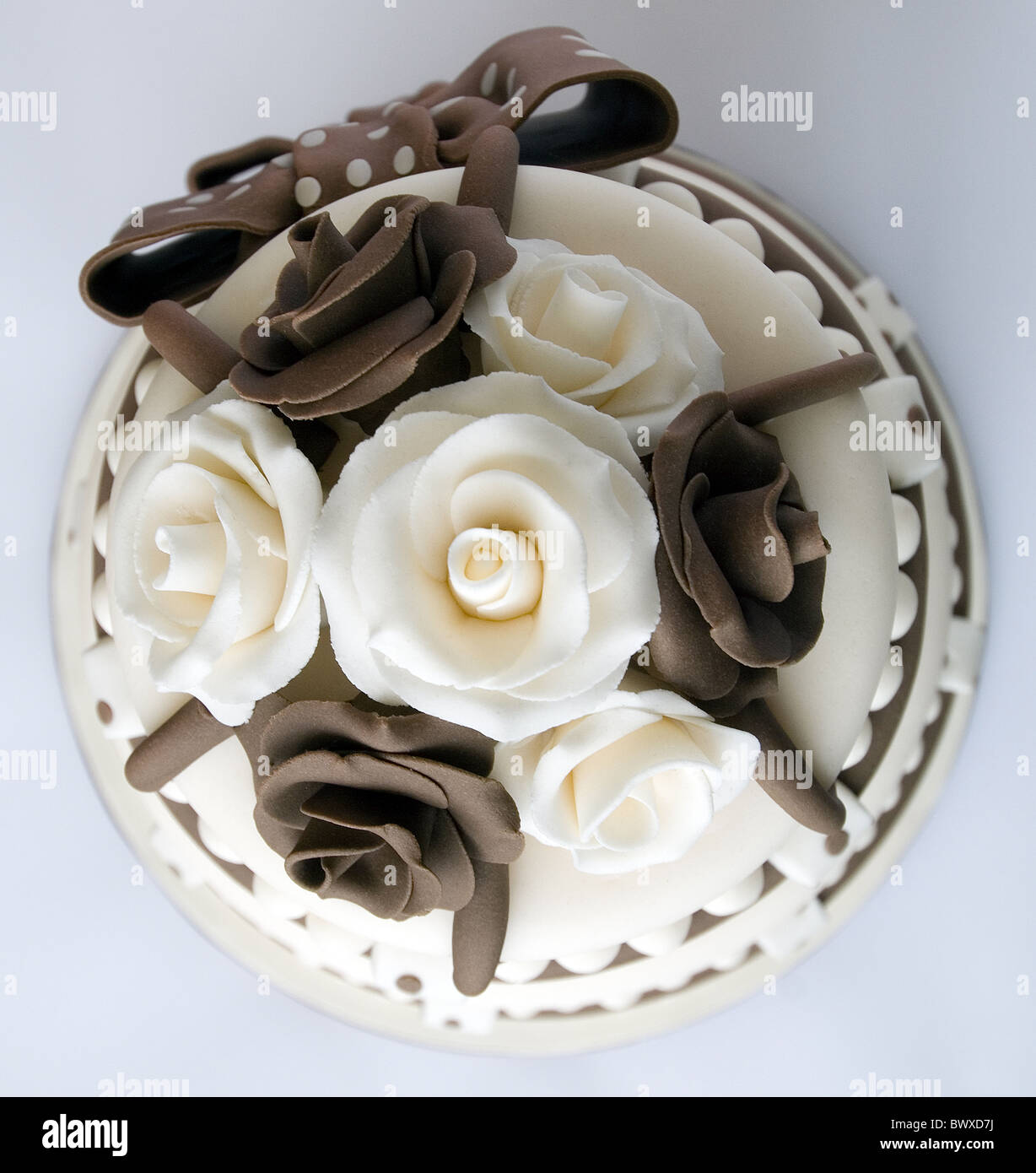 Un marrone e crema ghiacciata di celebrazione torta con le rose e archi Foto Stock