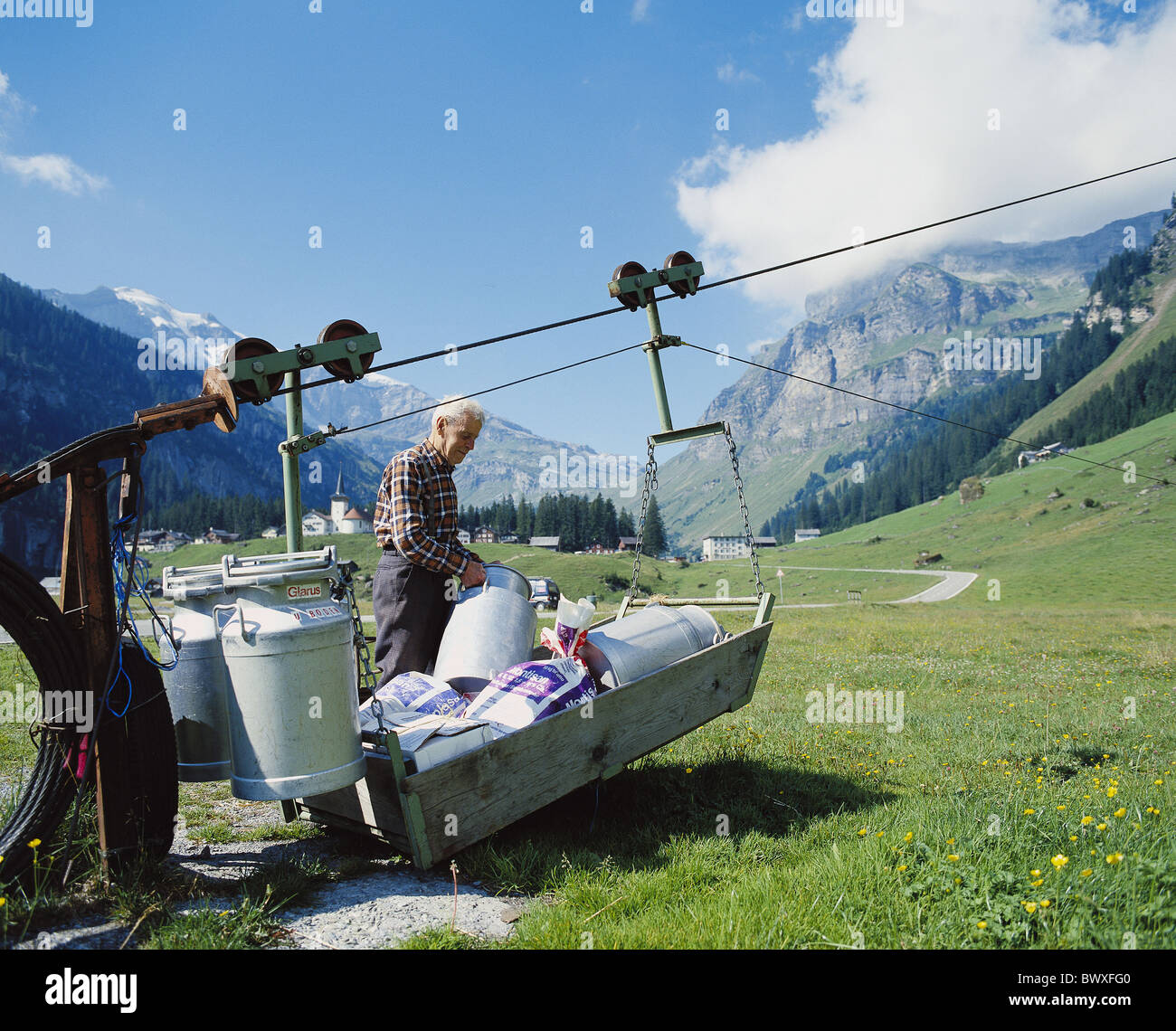 Trasformazione del latte latte Senner fune di trasporto treno pentole latte caricamento Urnerboden Svizzera Europa Cantone di Uri Foto Stock