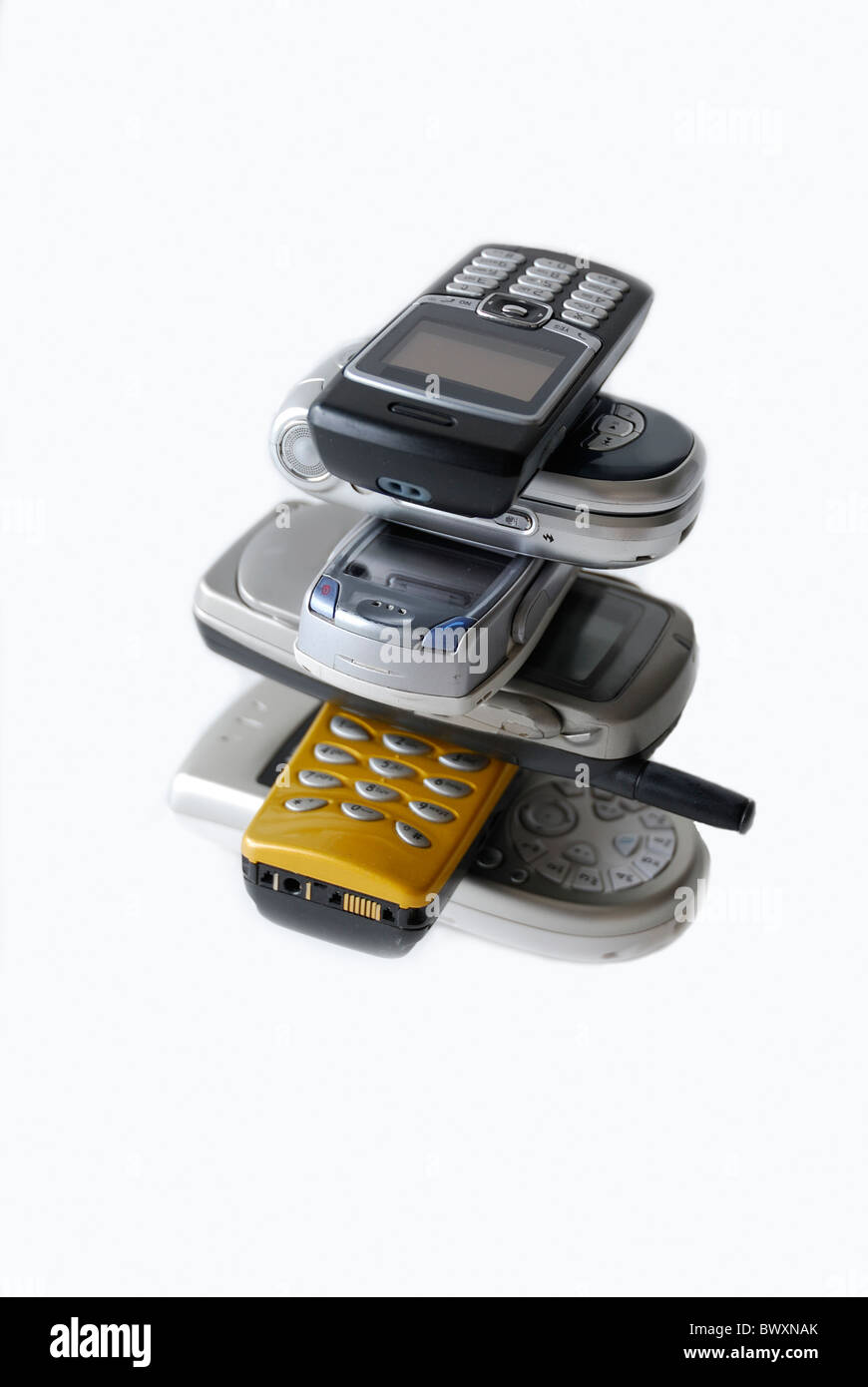 Una pila di sei diversi tipi di telefoni cellulari isolate su uno sfondo bianco Foto Stock