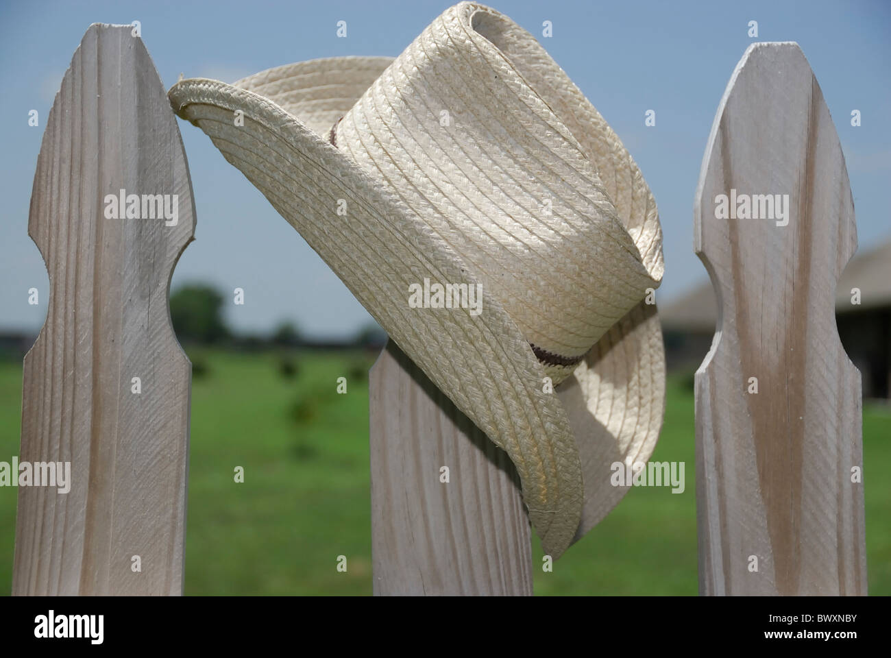 Un tan cappello da cowboy su un Picket Fence post contro il cielo blu Foto Stock
