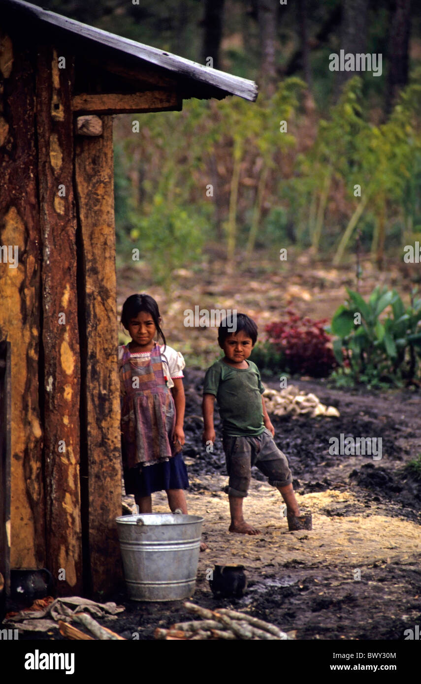 Due bambini guatemaltechi al di fuori di una casa in legno in un campo profughi vicino al confine, Santa Esmeralda, Chiapas, Messico. Foto Stock