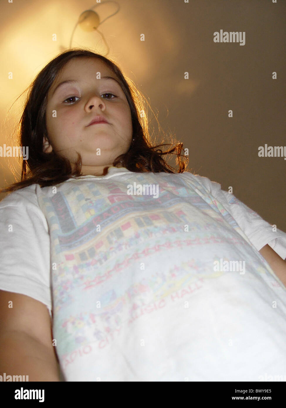 Panoramica gravi all'interno bambino ragazza problema problematico stand oversize da sotto Foto Stock