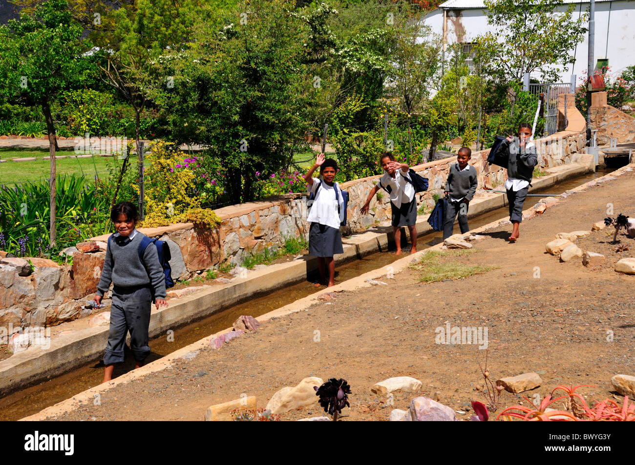 Un gruppo di bambini della scuola svolge nel condotto dell'acqua. Prince Albert, Sud Africa. Foto Stock