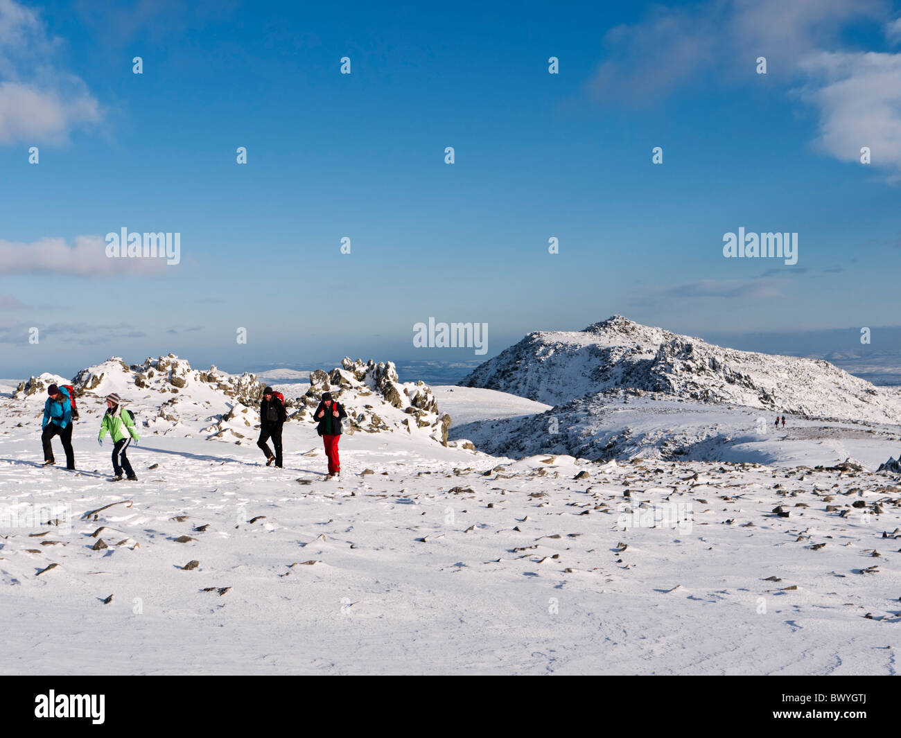 Hill walkers sul Glyder Fawr in inverno. Glyder Fach può essere visto in background. Snowdonia, il Galles del Nord Foto Stock