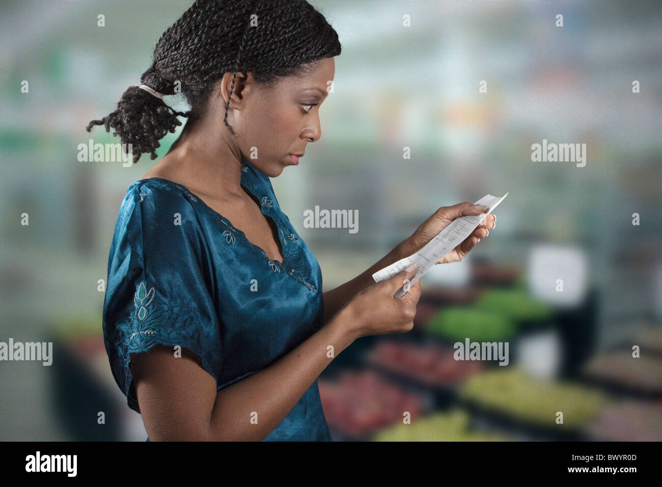 Nero donna guardando al negozio di generi alimentari shopping list Foto Stock