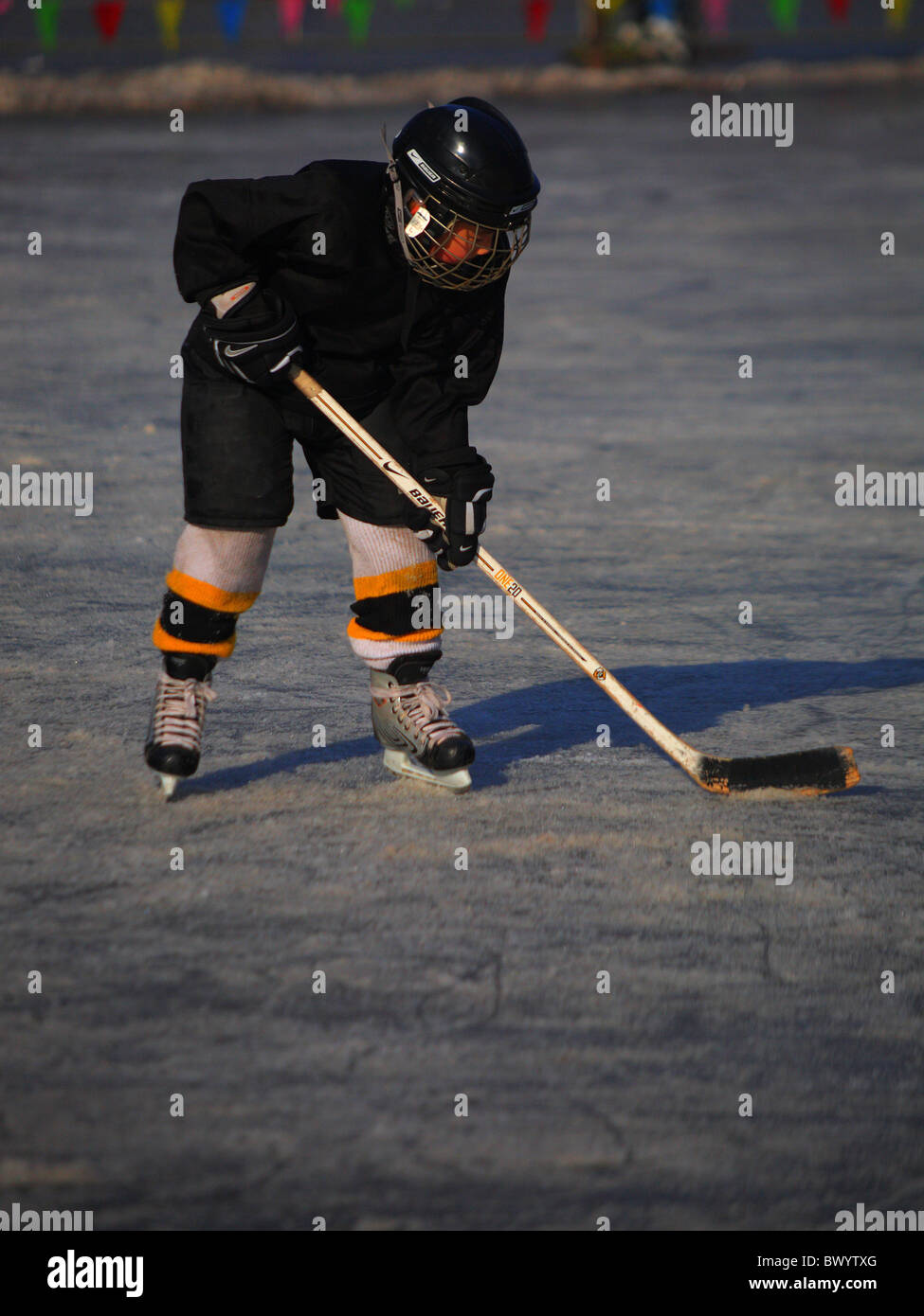 Bambini che giocano hockey su ghiaccio sulla superficie ghiacciata di l'Houhai Lake, Pechino, Cina Foto Stock