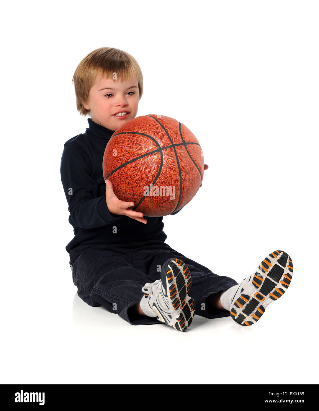 Ragazzo con la sindrome di Down giocando con la pallacanestro su sfondo bianco Foto Stock