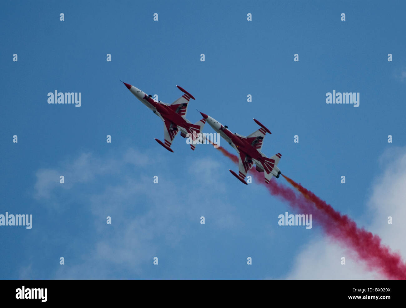 Due stelle turco Northrop NF-5 in formazione che viaggiano in unico file rosso brillante finale di fumo da destra in basso a sinistra superiore Foto Stock