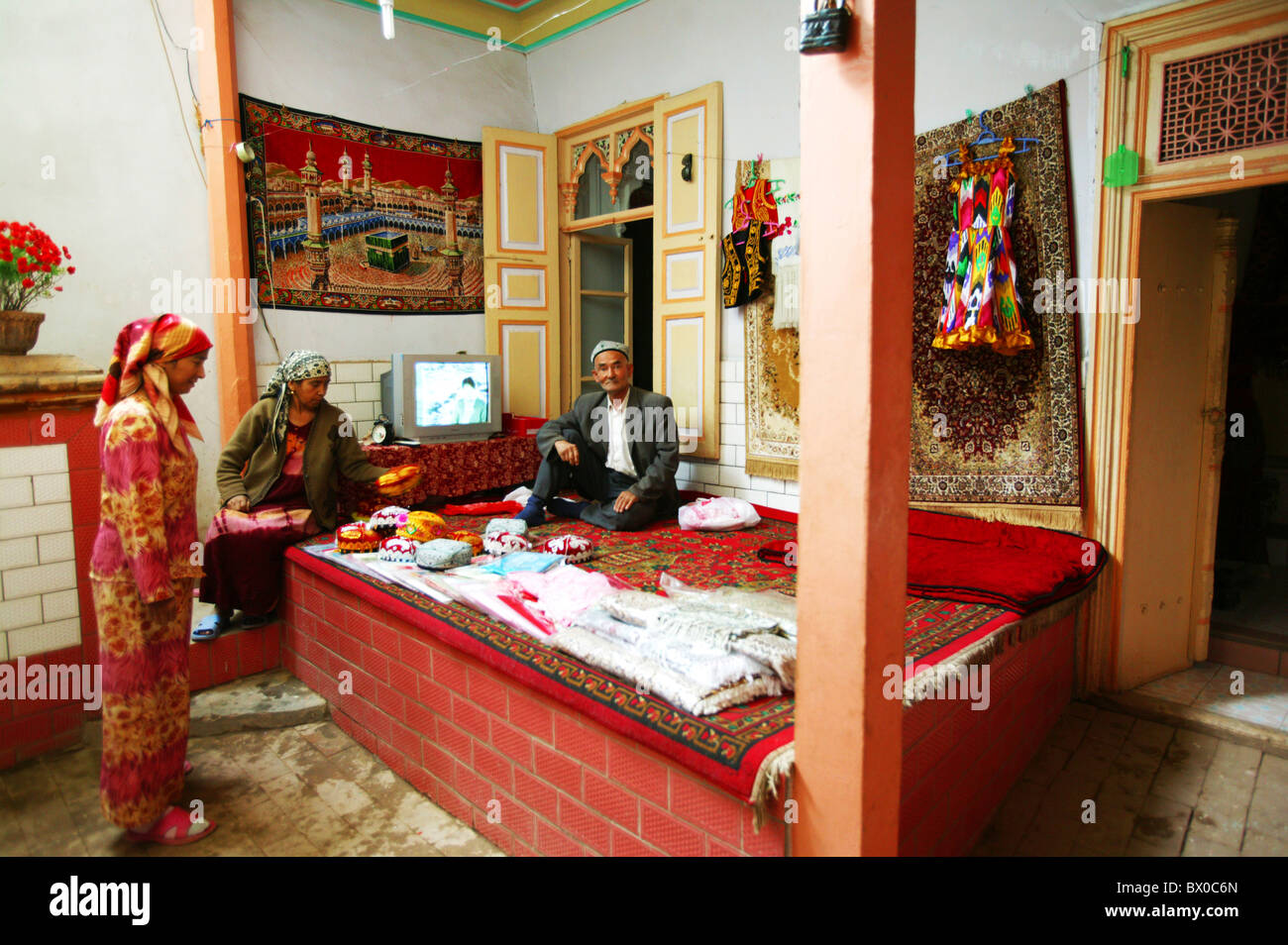 Famiglia Uygur nella loro casa tradizionale, Kashgar antica città, Xinjiang Uyghur Regione autonoma, Cina Foto Stock