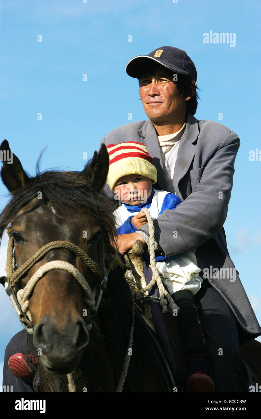 Il kazako uomo a cavallo con suo figlio, Nalat prateria, Ili kazako prefettura autonoma, Xinjiang, Cina Foto Stock