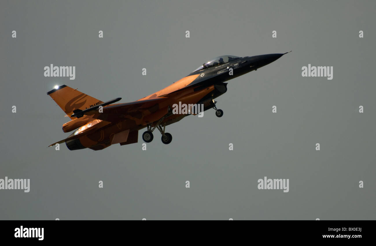 Dutch F-16A F16 tenendo landing gear jet battenti prendendo e arrampicata attraverso sky contro le nuvole scure tempestoso giorno Foto Stock