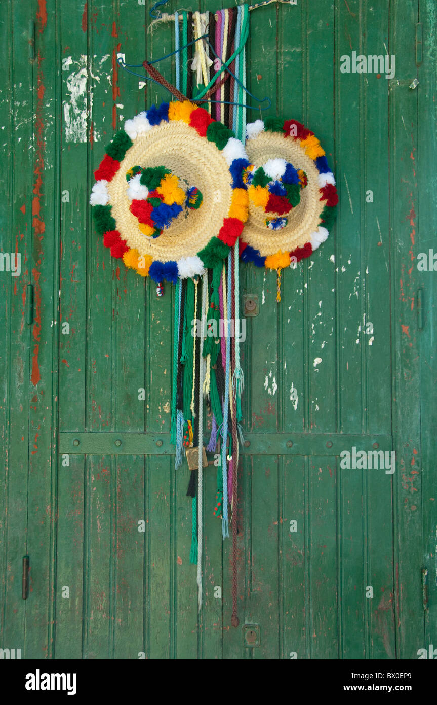 Il Marocco, Tetouan. Storica Medina bazaar. Agricoltore tradizionale di cappelli di paglia appesi su antichi verde porta di legno. Foto Stock