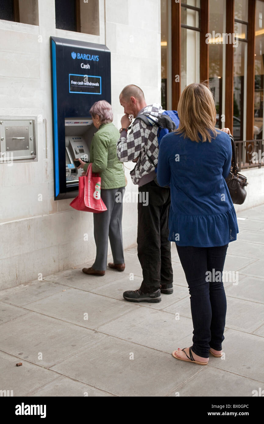I clienti in coda per utilizzare la macchina in contanti presso la Barclays Bank ATM Automated Teller Machine a Londra il San Giovanni Bosco. DAVID MANSELL Foto Stock