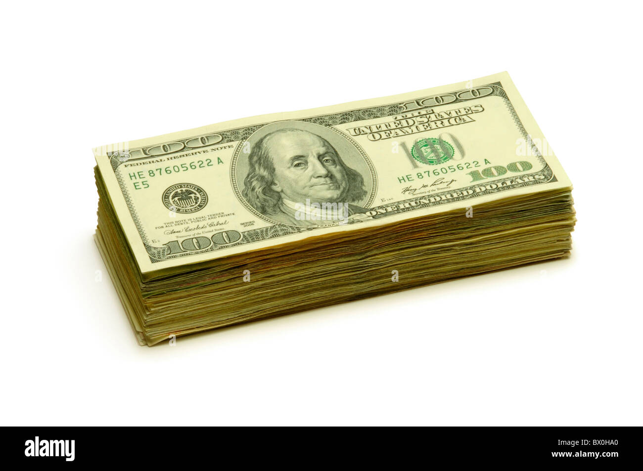 Pila di $100 banconote su una superficie bianca Foto Stock