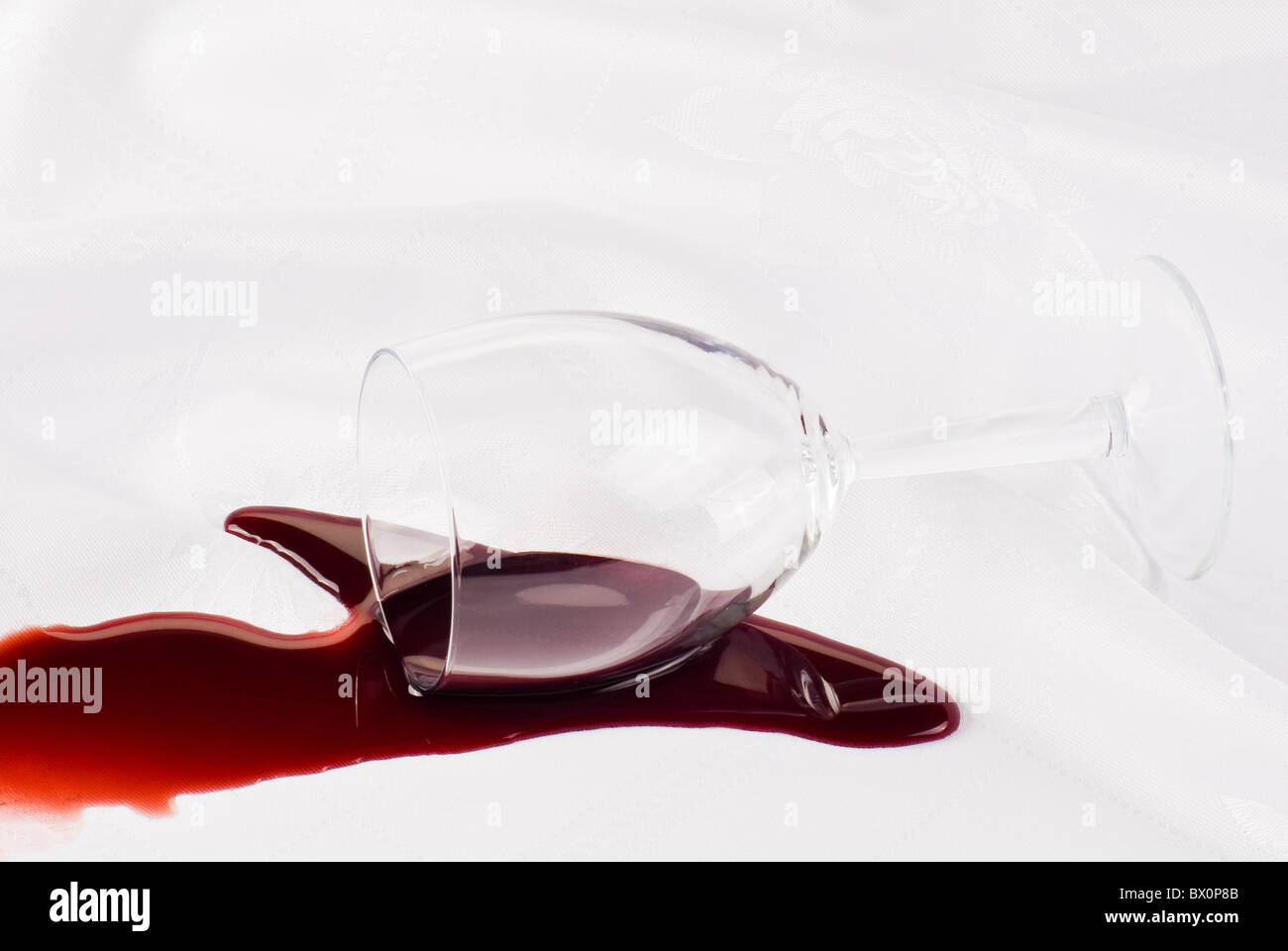 Bicchiere di vino di rovesciare sulla tovaglia Foto stock - Alamy