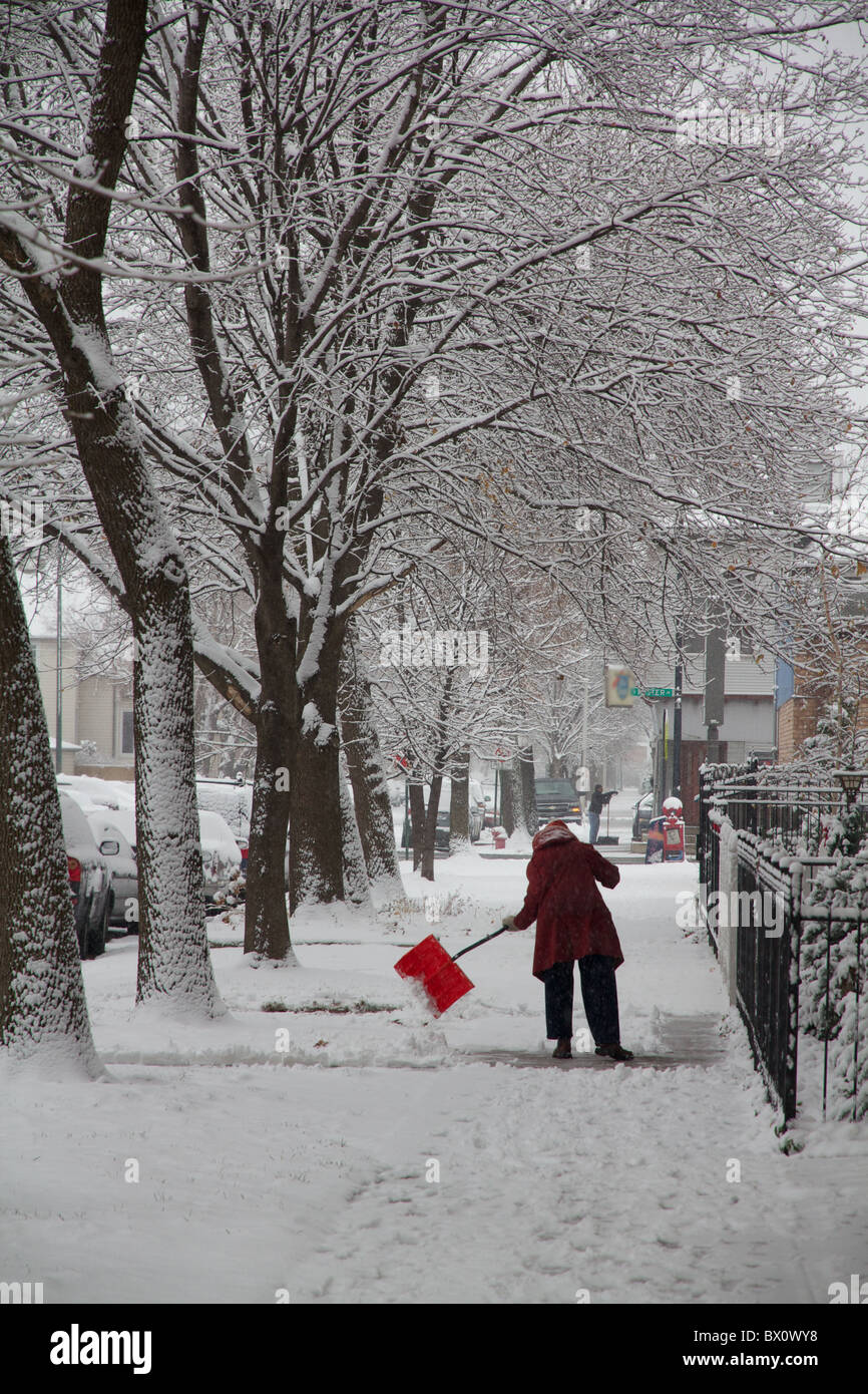 La donna la rimozione di neve dal marciapiede. Foto Stock